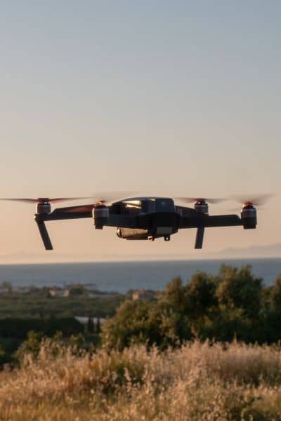 A survey drone flying over a wide landscape during daylight, showing how drone surveying captures terrain details and helps reveal hidden ground risks