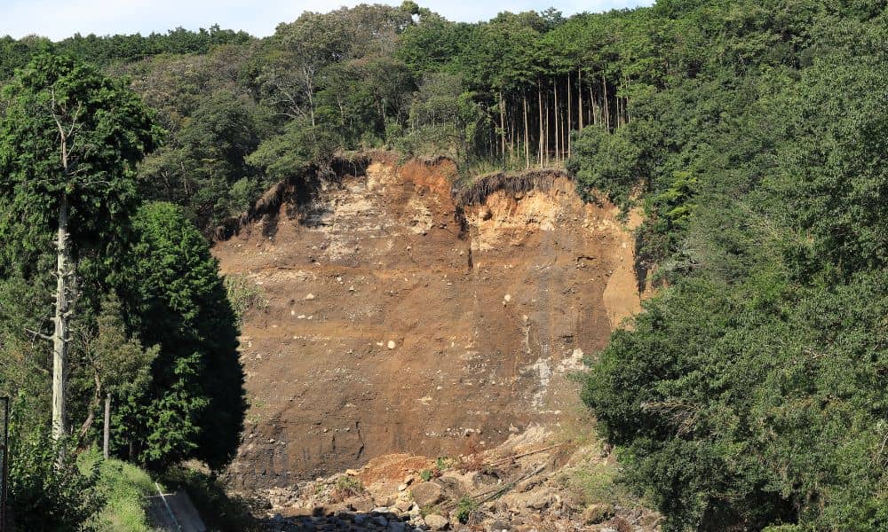 A steep hillside with exposed soil and erosion from a recent slope failure, showing the kind of hidden ground risks that drone surveying can reveal