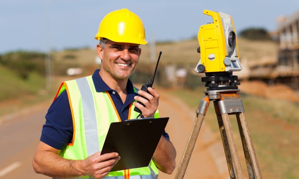 A professional land surveyor using field equipment during an Alta survey to accurately map property boundaries.