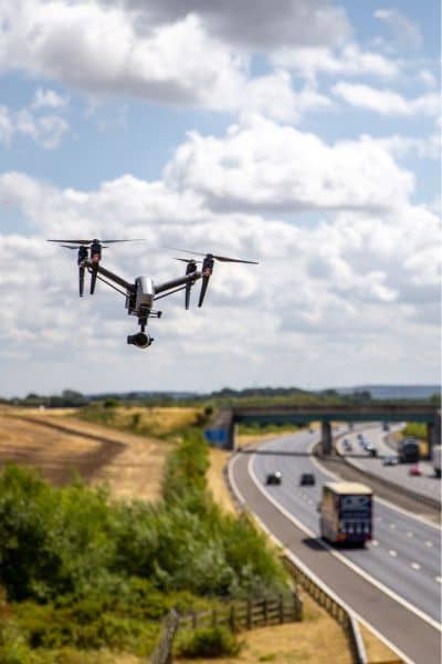 Drone conducting an aerial survey over a highway, capturing data for road construction and planning.