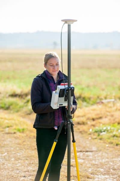 Land surveyor using GPS equipment in the field to gather elevation data for an elevation certificate