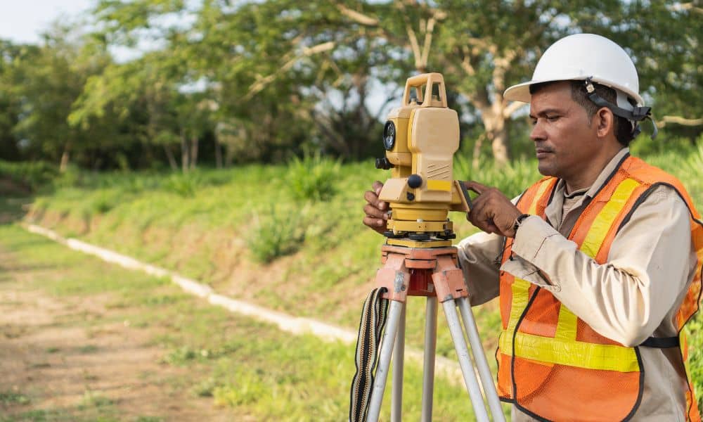 Surveyor checking land measurements on site before plans are submitted