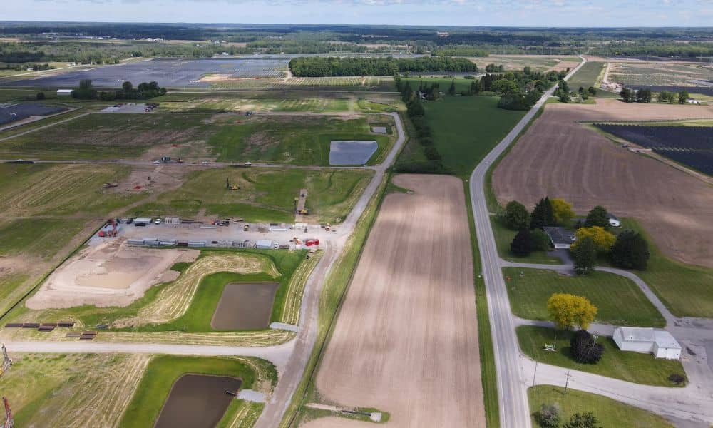 Aerial view of a developing property with access roads, cleared land, and surrounding fields, illustrating how drone surveying helps assess the site before design begins